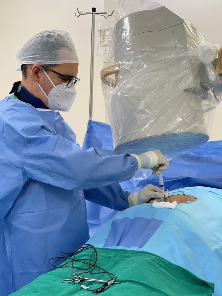 Médico de dor realizando infiltração de coluna em paciente com dor lombar